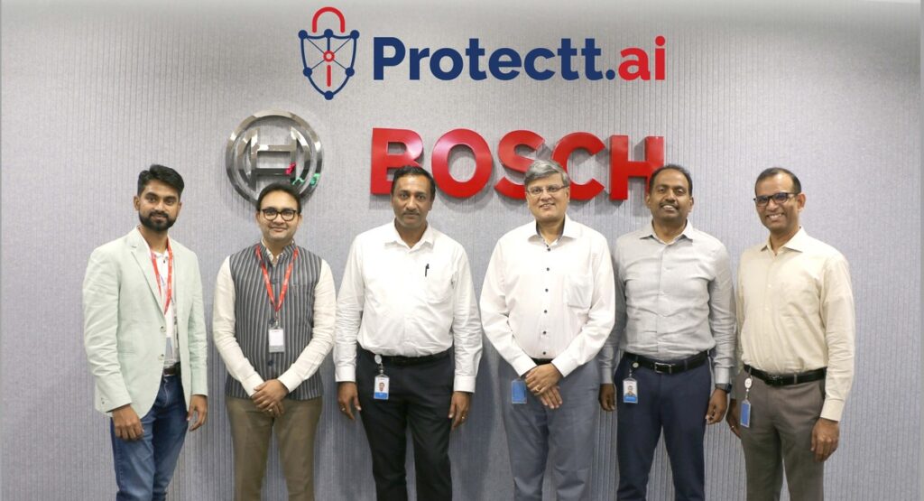 Protectt.ai and Bosch team members standing in front of Protectt.ai and Bosch logos